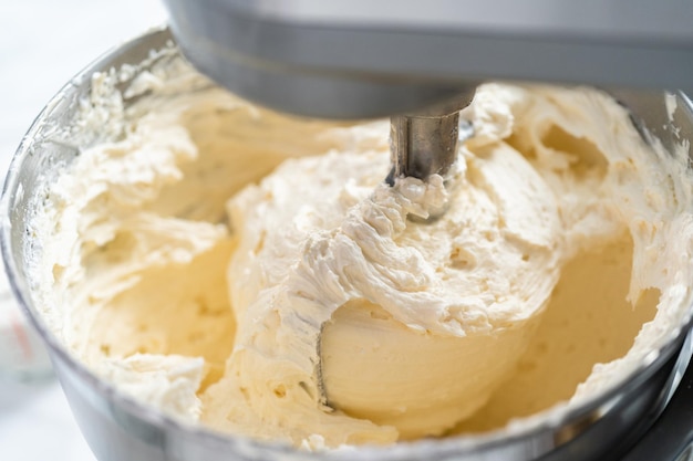 Buttercreme-Zuckerguss zum Dekorieren eines Vanillekuchens herstellen.