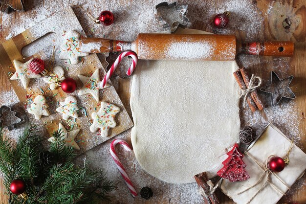 Butterkekse in verschiedenen Formen auf einem Holztisch mit Weihnachtsaccessoires kochen