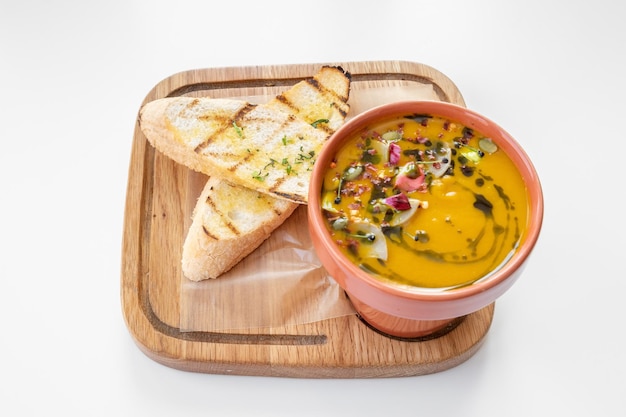 Butternut-Kürbis-Suppe mit Knoblauchbrot serviert in einer Schüssel isoliert auf grauem Hintergrund Draufsicht