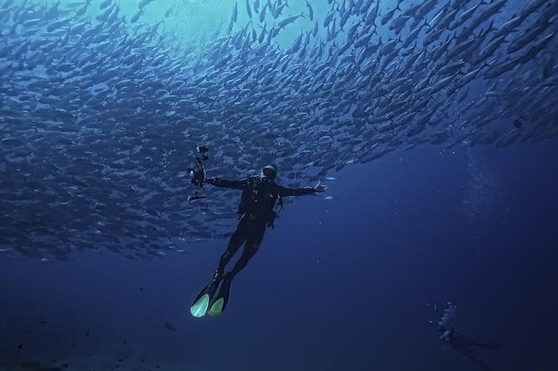 buzo y banco de peces, tornado de peces, hombre del ecosistema de vista submarina bajo el agua