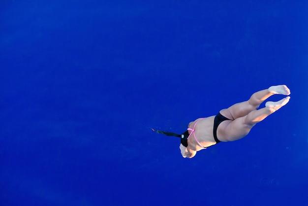 Buzo femenino salta a la piscina