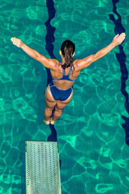 Buzo femenino saltando a la piscina