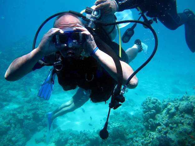 Buzo de hombre y hermoso colorido arrecife de coral bajo el agua