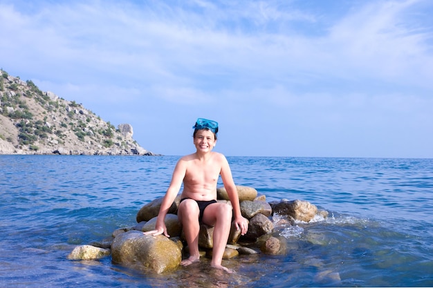 Buzo joven feliz en la playa del mar