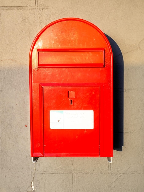 Buzón postal rojo en la pared de fondo