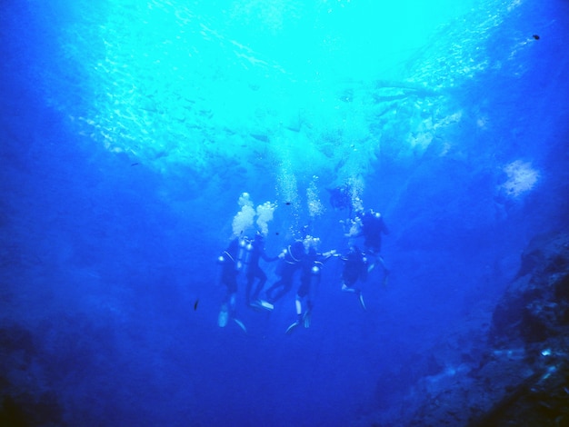 Buzos en laguna de agua azul