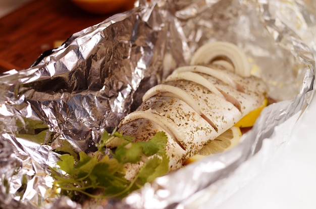 Caballa fresca preparada para cocinar al horno, marinada con especias, sal y limón. Pescado crudo en el papel de aluminio.