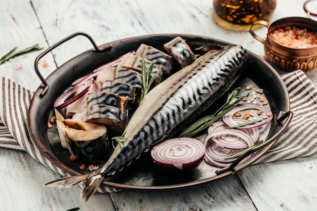 Caballa o arenque marinado con sal, cebolla y especias en bandeja de metal. Concepto de mariscos. vista superior