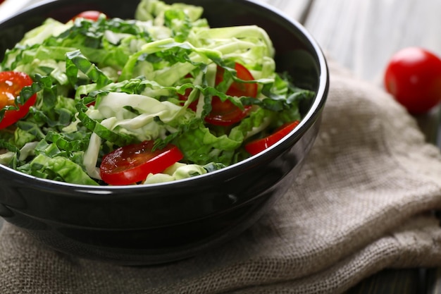 Caballa de Saboya y ensalada de tomate servida en un cuenco en una mesa de madera