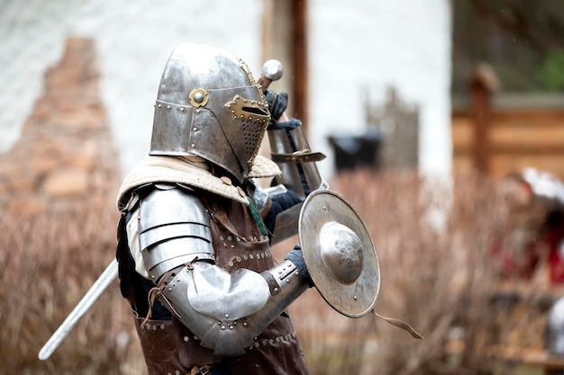 Caballero medieval antiguo en armadura con un escudo protector de metal Edad de hierro