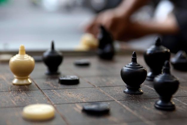 Un caballero negro brillante en un tablero de ajedrez tailandés de madera