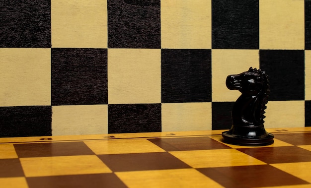 Caballero negro solo en un tablero de ajedrez. Concepto de pasión, liderazgo.
