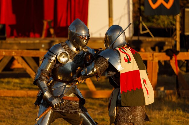 Los caballeros con armaduras medievales luchan en el torneo en el verano. Foto de alta calidad