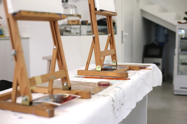 Caballetes de madera sobre una mesa en un taller de arte closeup