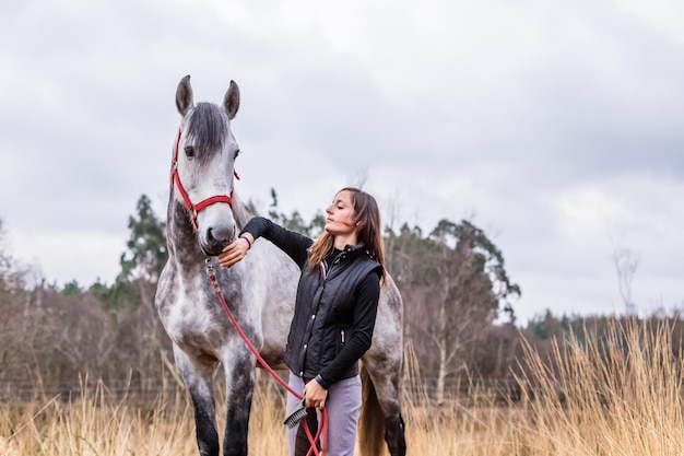 Caballo español puro andaluz mujer de mediana edad hispana de la escuela de equitación equitación