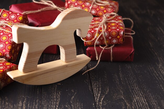 Caballo de madera frente a un montón de regalos