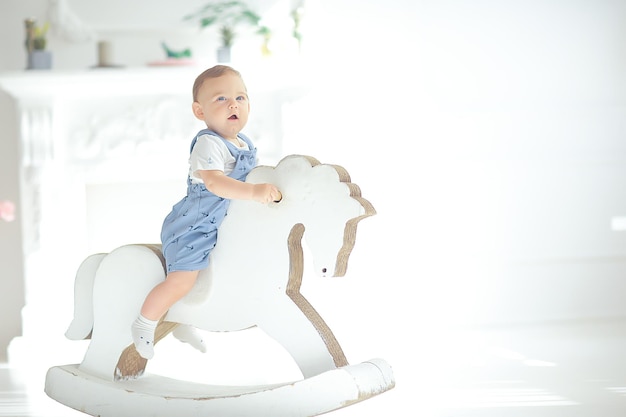 caballo mecedor para niños / niño pequeño montando un caballo de juguete, mecedora vintage de juguete para niños