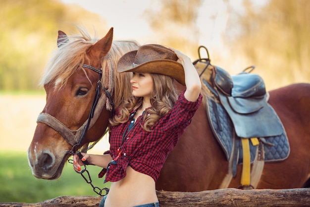 Caballo y niña con sombrero de vaquero.