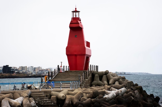 Caballo de pony rojo Iho Tewoo Faros y tetrápodos para rompeolas y disipación de agua de olas previenen la erosión en el océano marino en la playa de Iho Tewoo para la visita de viaje de los coreanos en la isla de Jeju Corea del Sur