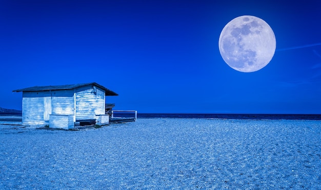 Cabaña blanca en la playa por la noche