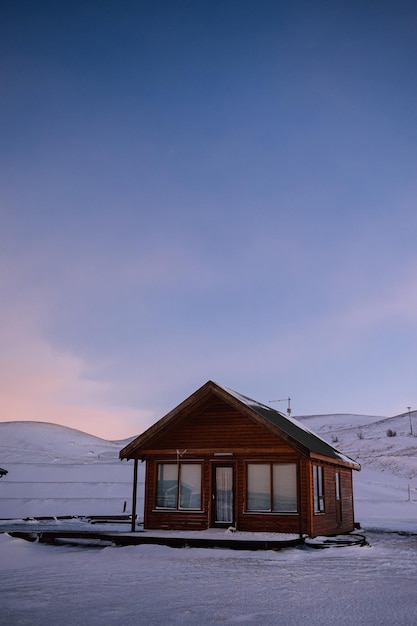 Cabaña de madera aislada en medio de la nieve al atardecer en Islandia