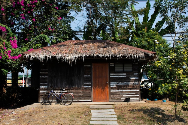 Cabaña de madera retro vintage o cabaña de madera con bicicleta clásica para los tailandeses y el descanso de los viajeros extranjeros relajarse en la granja del parque del jardín en el pueblo rural de la ciudad de Sam Phran en Nakhon Pathom Tailandia