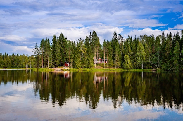 Cabaña de madera roja junto al lago en la Finlandia rural