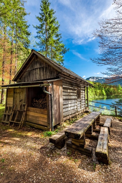 Cabaña de madera del viejo bosque en los Alpes en el lago