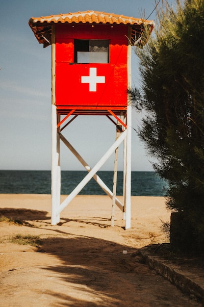 Foto cabaña roja en la playa contra el cielo