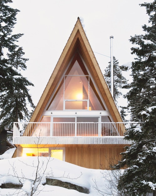 una cabaña con un techo cubierto de nieve y una luz en la parte superior
