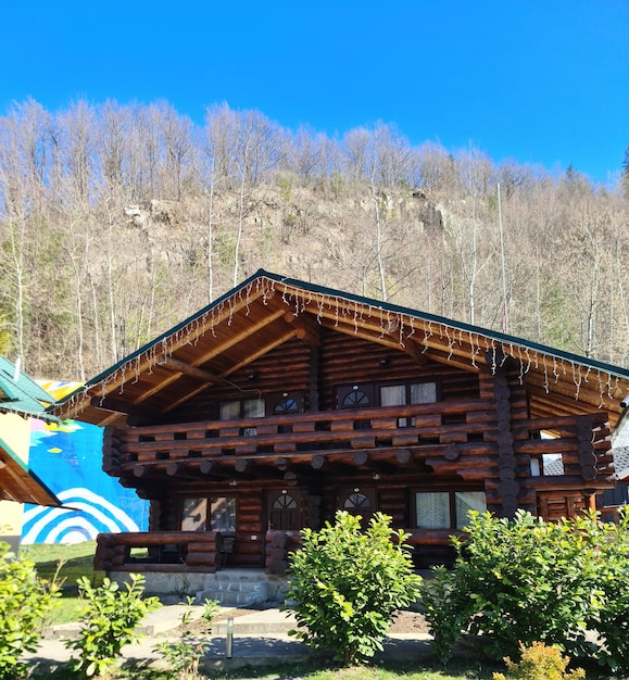 Una cabaña de troncos con techo azul y techo verde.