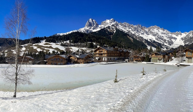 Cabanas de montanha ao lado de um lago de gelo congelado no inverno