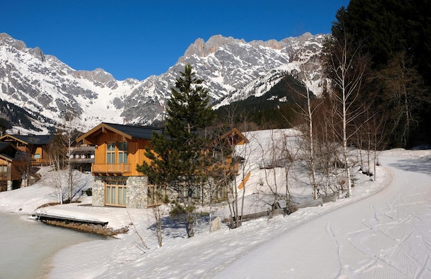 Cabanas de montanha ao lado de um lago de gelo congelado no inverno