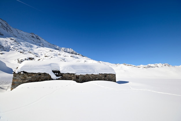 Cabanas de pasto velhas no fundo cênico de inverno, inverno nos alpes