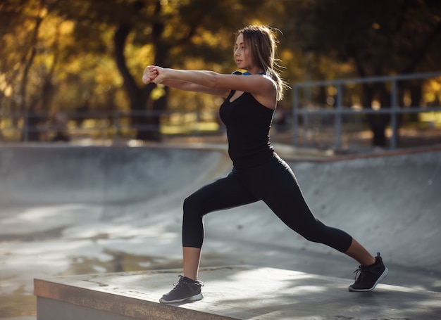 Cabe a mulher no sportswear praticando aeróbica em um parque esportivo. Conceito de estilo de vida saudável