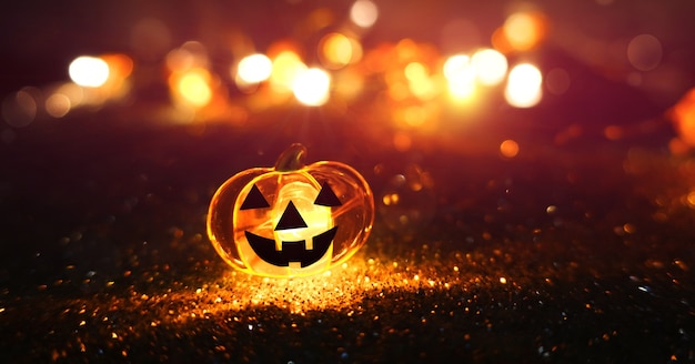 Foto cabeça de abóbora brilhante de néon no fundo abstrato bokeh turva. fundo festivo de halloween