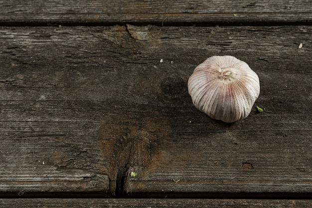 Foto cabeça de alho em um fundo de madeira. propriedades médicas do alho. especiarias naturais. close-up de alho. especiarias picantes. desinfetantes naturais.