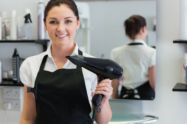 Cabeleireira feminina segurando secador de cabelo