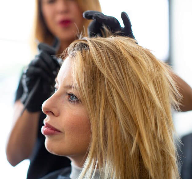 Foto cabeleireira manchando o cabelo de uma cliente