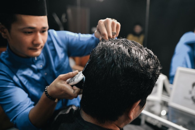 Cabeleireiro a cortar o cabelo do cliente