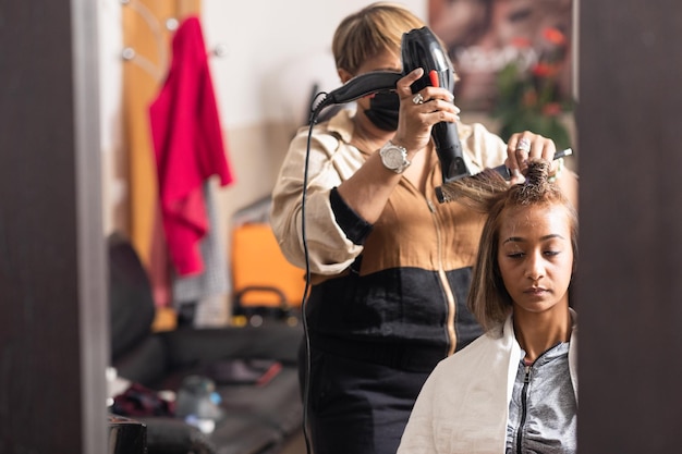 Foto cabeleireiro a pentear os cabelos dos clientes no salão