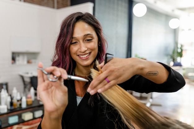 Cabeleireiro aparando o cabelo da cliente em um salão de beleza