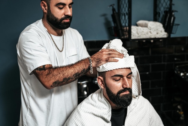 Cabeleireiro atendendo um cliente em uma barbearia