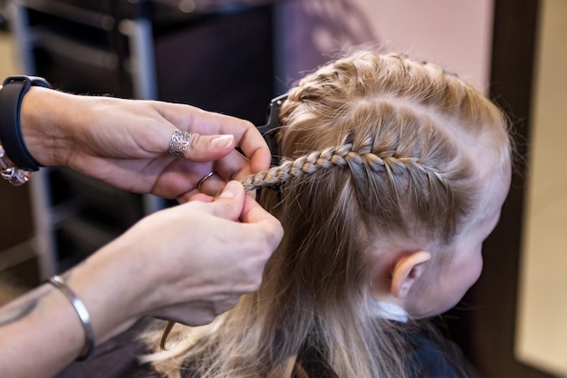 Cabeleireiro cabeleireiro faz penteado para bebê na barbearia de perto  barbeiro faz penteado de tranças da moda