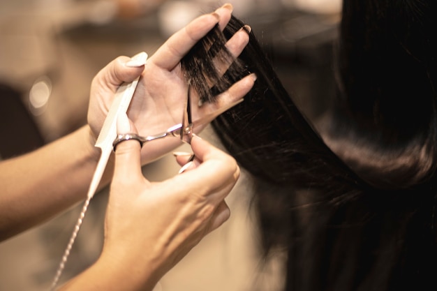 Cabeleireiro corta cabelo comprido em uma garota