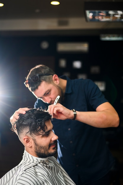 Foto cabeleireiro, dando ao cliente um corte de cabelo fresco