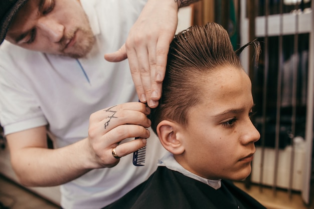 Cabeleireiro de cortes de cabelo de adolescente na barbearia