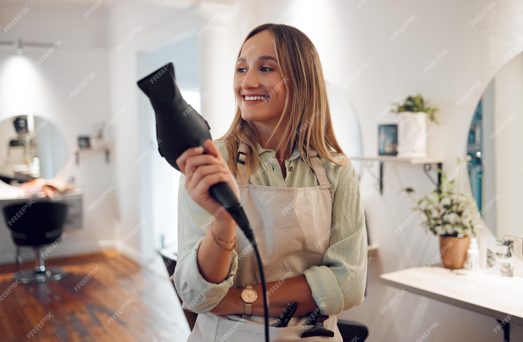 Cliente do sexo feminino feliz usando secador de cabelo no salão de  cabeleireiro. mulher sentada na cadeira no hairsalon. negócios de moda e  beleza, serviços profissionais