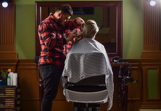 Cabeleireiro em barbearia homem em salão de cabeleireiro com barba e bigodes de corte de cabelo hipster