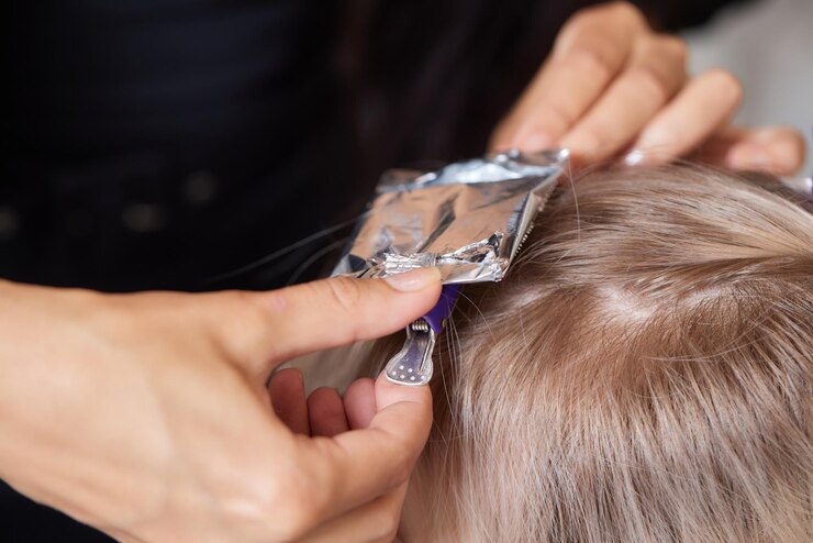 Foto cabeleireiro faz bouffant usando pente em mechas finas técnica shatush para clarear o cabelo